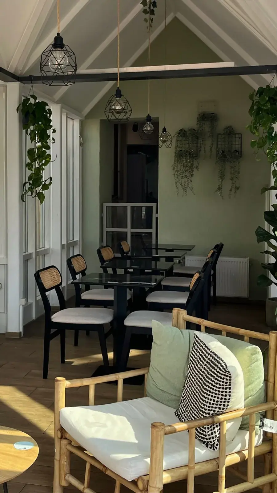 Wintergarten im matchas Café Gießen mit Cane-Stühlen und Pflanzen
